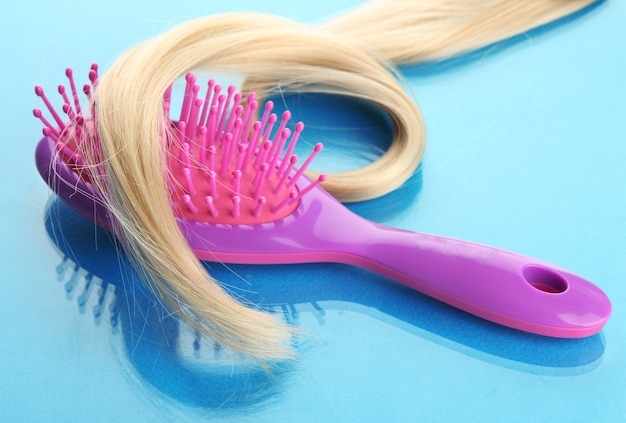 Comb brush with hair,  on blue surface