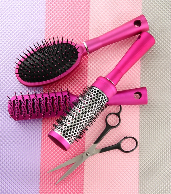 Comb brushes and cutting shears on bright background