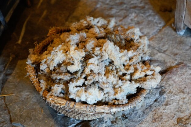 combed cut wool virgin raw from a sheep in a wicker basket