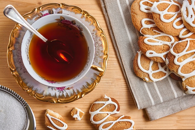 Combinatie van eten met thee en koekjes op een houten tafel van bovenaf