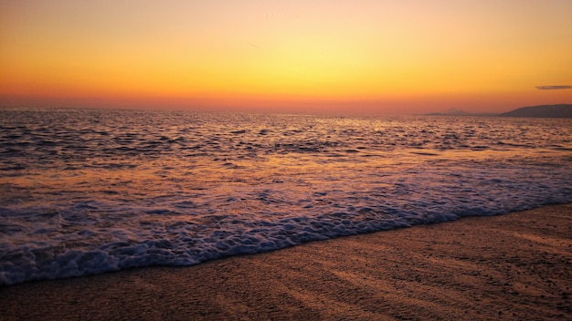 Сочетание заката и пляжа. красочный оранжевый закат на пляже