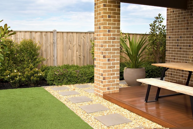 Photo combinations of artificial grass paving tiles decking plants and pebble