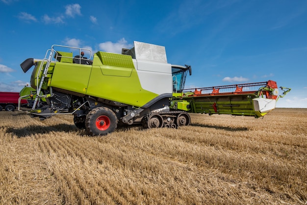 Combine harvester in the foreground and the field at stubble of harvest