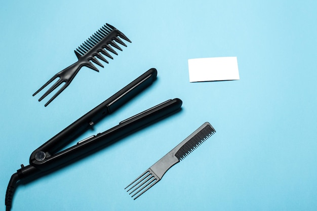 Combs and hairdresser tools on blue background top view