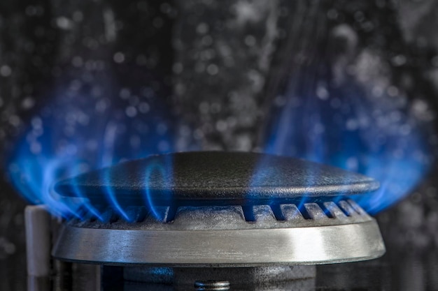 사진 천연 가스 프로판의 연소 검정색 배경에 있는 가스 스토브 푸른 불꽃이 닫혀 있는 가스 주방 스토브 조각 에너지 위기 개념 가격 또는 가스 가격 상승