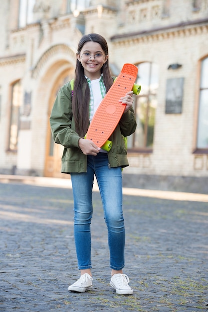 Come to skate and have fun. Happy kid hold penny board. Little skater urban outdoors. Board for transportation. Recreational activity. Action sport. Travel and adventure. Street skateboarding.