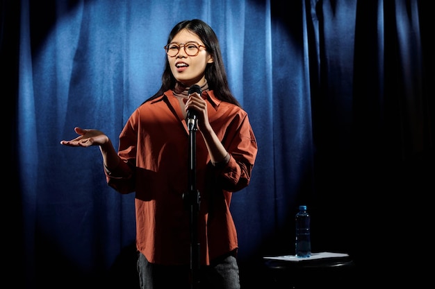 Comedian in eyeglasses and brown shirt