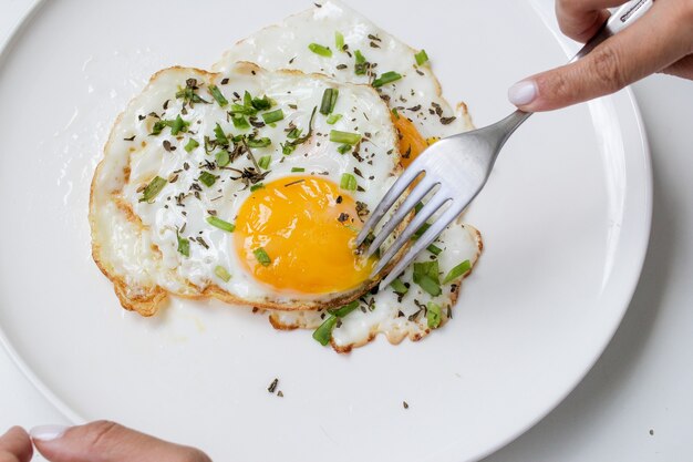 Comer un desayuno healhty huevo cocido con detalles verdes orgÃÂÃÂ¡nicos y la cuchara vista de cerca