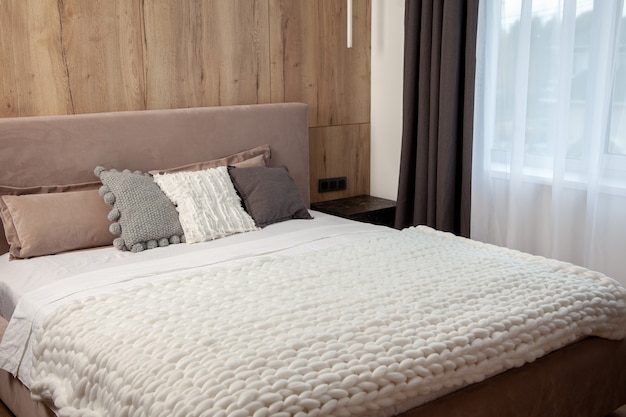 Comfortabel bed met kussens in de kamer. Stijlvol interieur