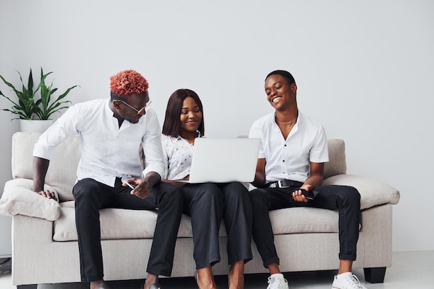 Comfortabele bank Met behulp van laptop Groep Afro-Amerikaanse zakenmensen die samen aan het werk zijn