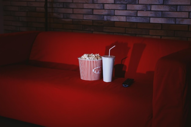 Comfortabele bank met popcorndrankje en afstandsbediening voor binnen Thuisbioscoop