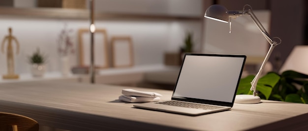 Фото Комфортное современное рабочее пространство домашнего офиса с макетом портативного компьютера при низком освещении 3d-рендеринга