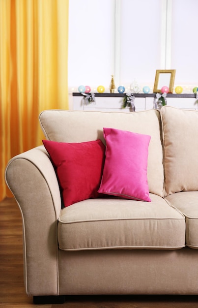 Comfortable modern sofa with bright pillows in the room close up