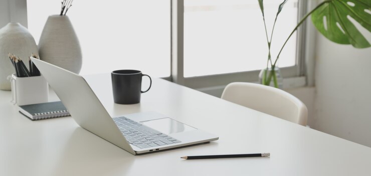 Photo comfortable office room with laptop computer and office supplies on white wooden table