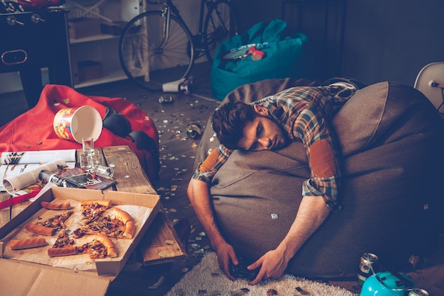 comfortable place to pass out. young handsome man passed out on bean bag 