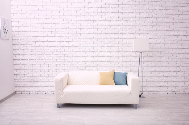 Comfortable sofa on brick wall background