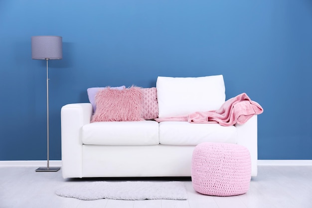 Comfortable sofa on color wall background