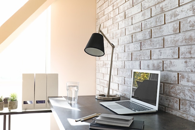 Photo comfortable workplace near light brick wall