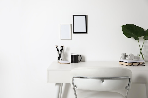 Foto posto di lavoro confortevole con scrivania bianca vicino al muro di casa