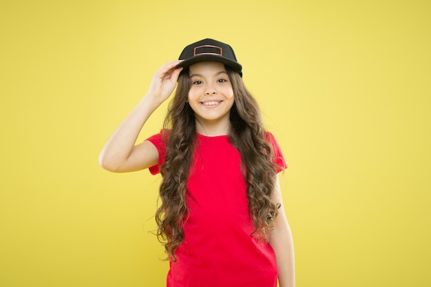 Comfy and cool Girl long curly hair wear cap Must have street style accessory trends Modern fashion Kids fashion Girl cute child wear cap or snapback hat Little girl wearing baseball cap