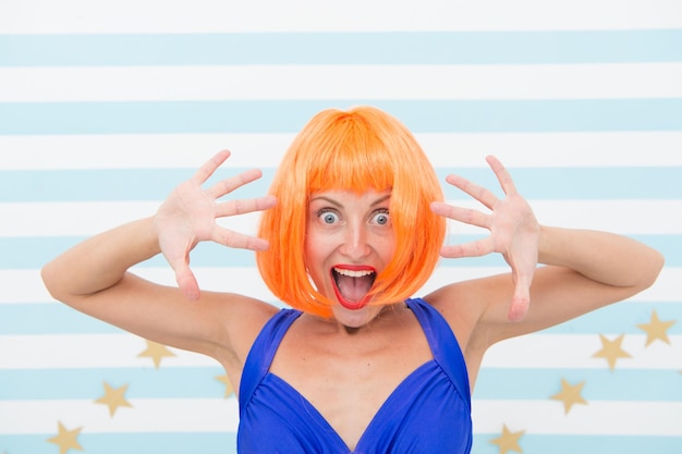 Comic actress concept woman playful mood having fun lady
actress practicing performance she likes bright outfit girl posing
striped background of studio lady red ginger wig posing in blue
dress