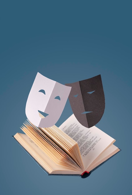 Фото Комические и трагические бумажные театральные маски над фотокопией открытой книги
