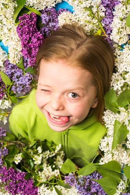 Comic grimace funny emotion crazy facial Teenager girl with bouquet of purple and white lilac