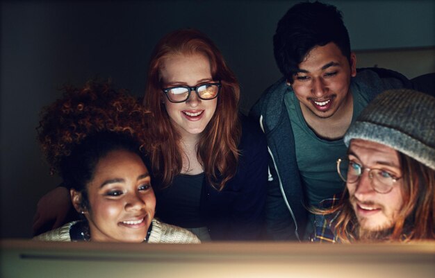 Coming together and giving their all Shot of a business team looking at a computer screen on a night shift at the office