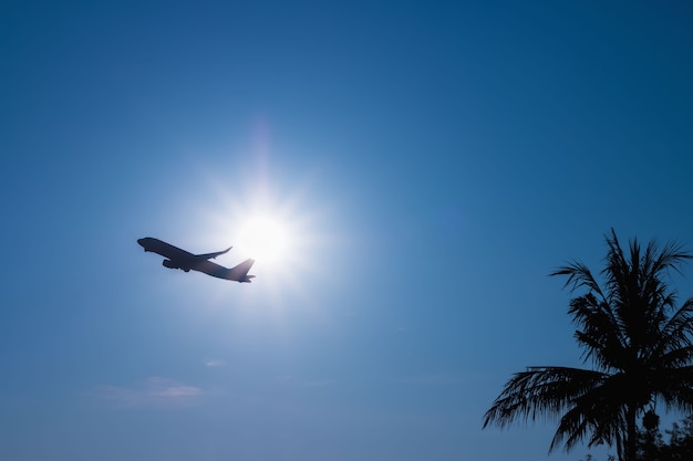 Foto aeroplano commerciale volare sopra le nuvole attraverso la luce del sole e il bel cielo blu.