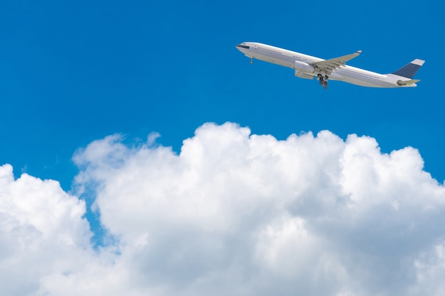 Фото Коммерческий самолет, пролетая над ярким голубым небом и белыми облаками.