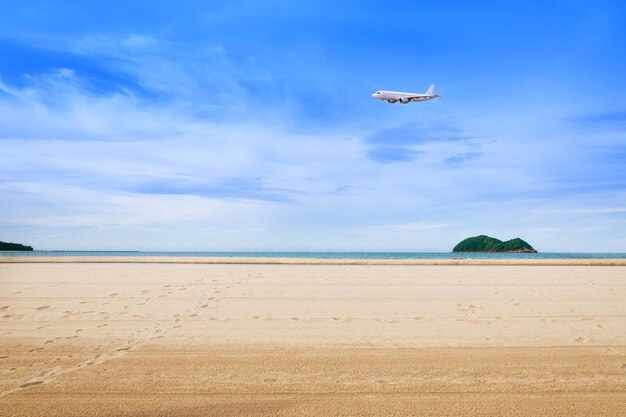 Commercial airplane above sea in summer season and clear blue sky over beautiful scenery sandy beach background Concept business travel and transportation summer vacation travel