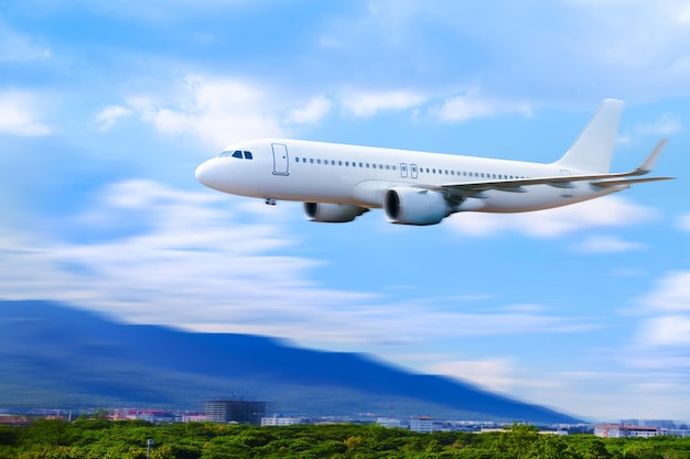 Commercial airplane above in summer season and blue sky over beautiful scenery nature backgroundconcept business travel and transportation summer vacation travel