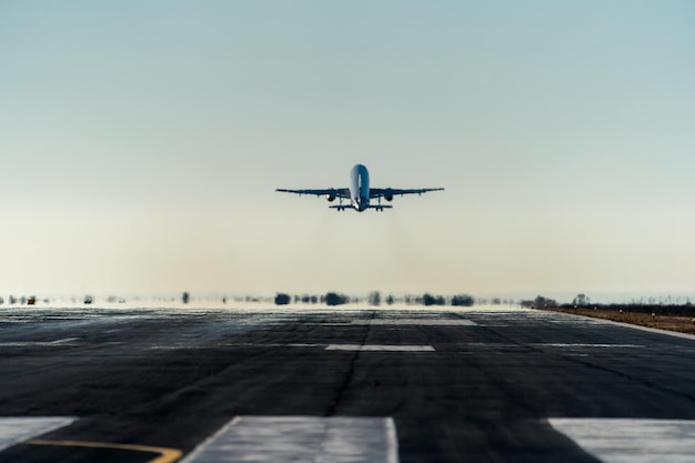 Photo commercial airplane taking off at sunset