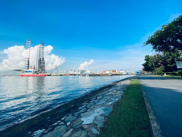 Commercial dock by sea against blue sky