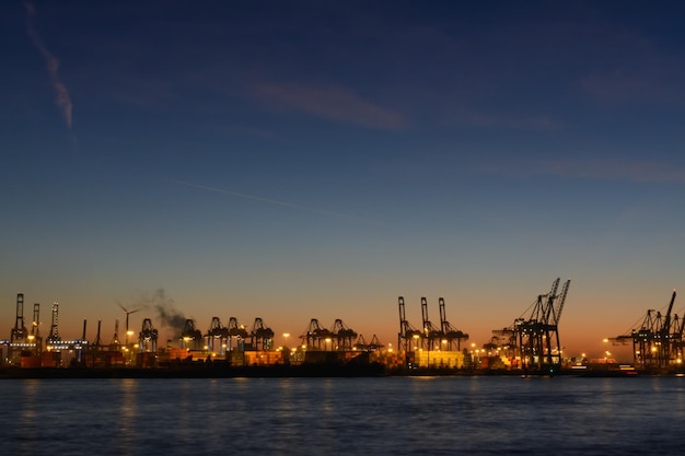 Photo commercial dock by sea against sky at night