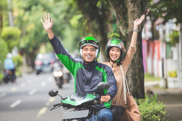 Commercial motorcycle taxi driver taking his passenger to her destination