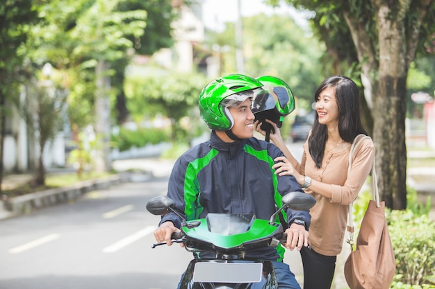 Commercial motorcycle taxi driver taking his passenger