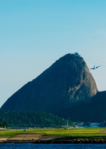 Commercial plane taking off from Santos Dumont national airport with Sugarloaf mountain in the background