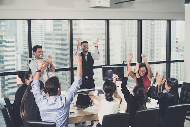 Commercieel team dat een triomf met omhoog wapens viert