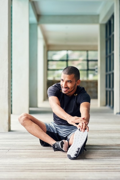 健康と体調を維持することを約束します外に伸びるスポーティな若い男のショット