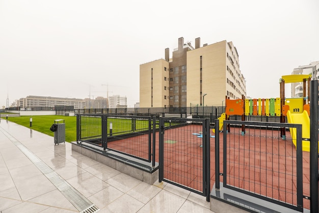Photo common areas with playgrounds and lawned gardens in an urbanization of a neighborhood under construction on a day of copious rain