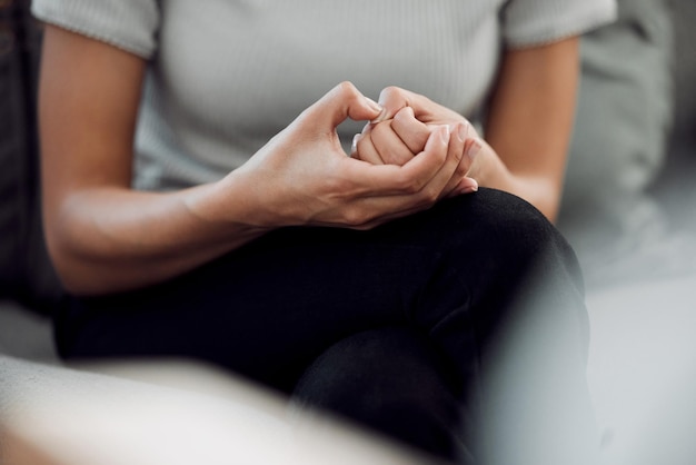 A common sign of anxiety is subconscious skin picking Cropped shot of an unrecognisable woman sitting alone and feeling anxious while picking the skin on her nails