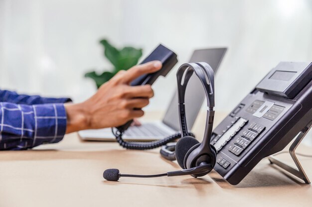 Foto communicatieondersteuning, callcenter en helpdesk voor klantenservice. telefoontoestellen met voip-headset in office. customer service support (callcenter) concept.