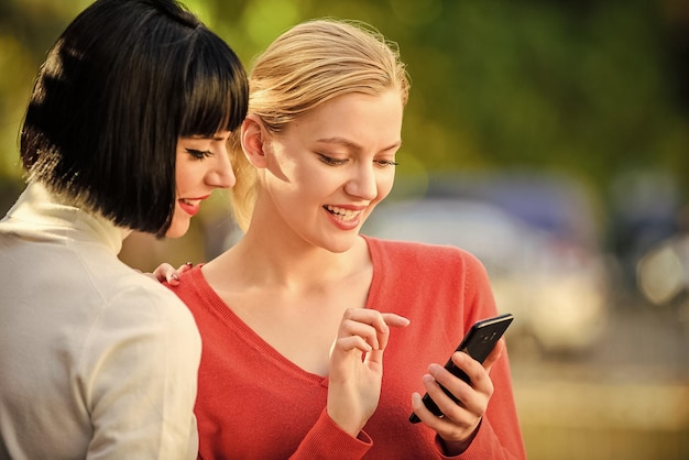 사진 온라인 의사 소통 전화를보고 의사 소통하는 소녀 온라인 구매 야외에서 통신하는 스마트 폰을 가진 두 여성 소셜 네트워크 개념 공유 링크 현대 기술 인터넷 서핑