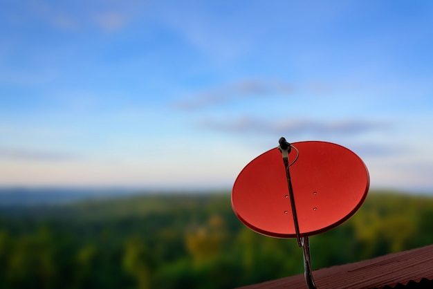 Photo communication concept with satellite dish on blue sky background