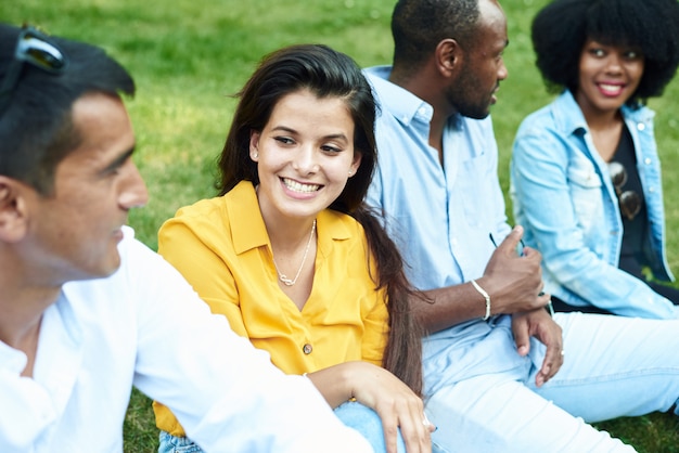 Photo communication of friends of different races on the background of grass in the park