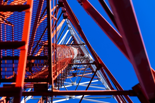 The communication tower stands against the sky with a bottomup view Closeup