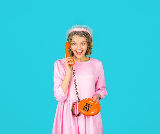 Communication young woman talking on retro phone smiling woman in pink dress with telephone handset