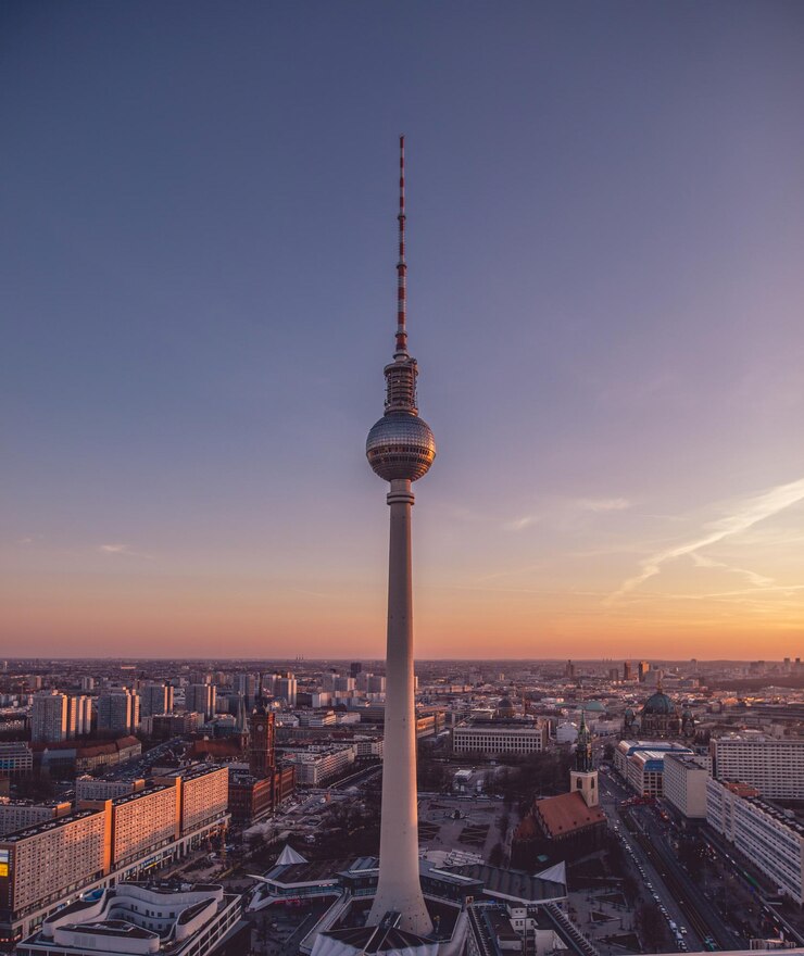 Photo communications tower in city against sky during sunset