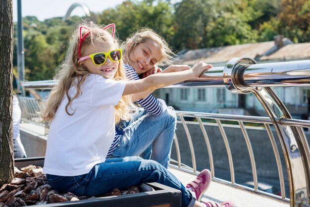 Communiceer en ontspan de kinderen van twee meisjes. Stedelijke achtergrond